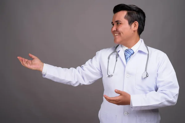 Multi-etnische jongeman arts tegen de grijze achtergrond — Stockfoto