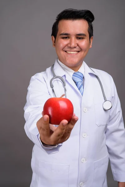 Joven médico hombre multiétnico contra el fondo gris —  Fotos de Stock
