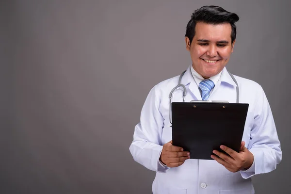 Молодой многонациональный врач на сером фоне — стоковое фото
