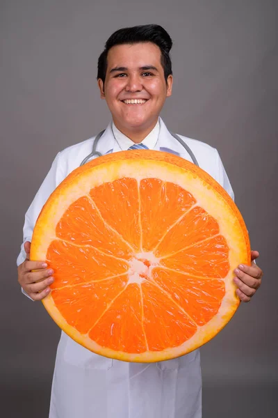 Young multi-ethnic man doctor against gray background — Stock Photo, Image