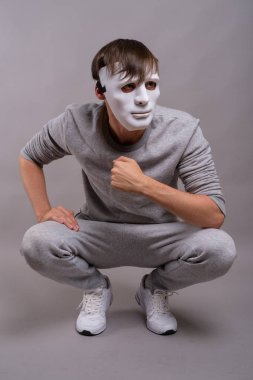 Yakışıklı delikanlı gri arka plan beyaz maske takıyor