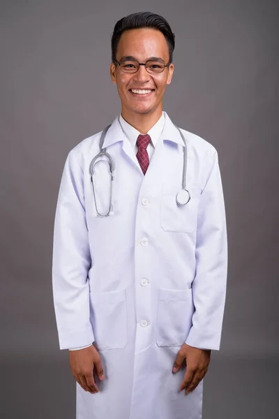 Joven guapo indio hombre médico contra gris fondo — Foto de Stock