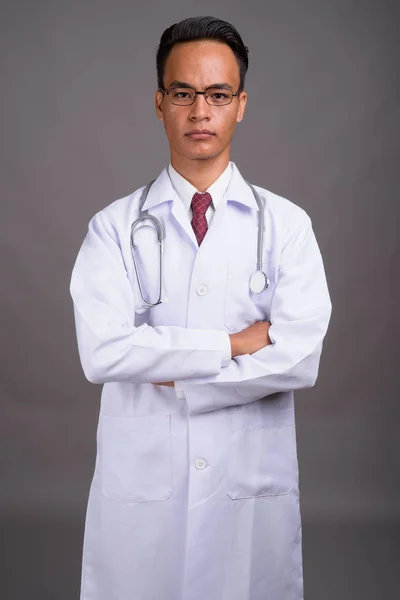 Vacker indisk ung läkare mot grå bakgrund — Stockfoto