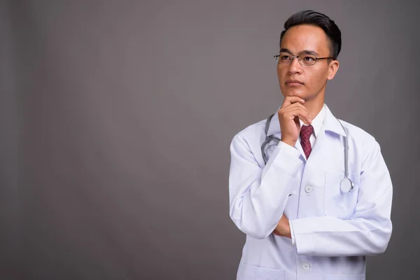 Joven guapo indio hombre médico contra gris fondo — Foto de Stock