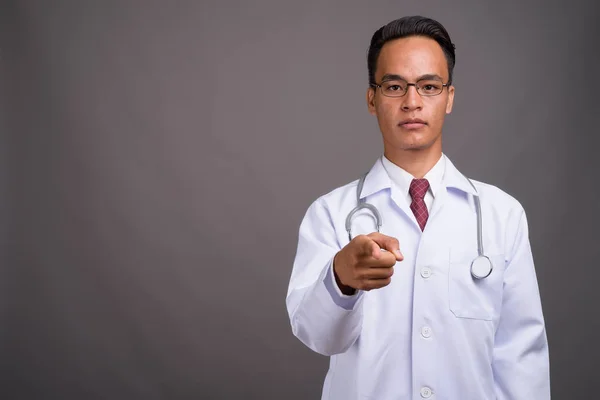 Joven guapo indio hombre médico contra gris fondo — Foto de Stock