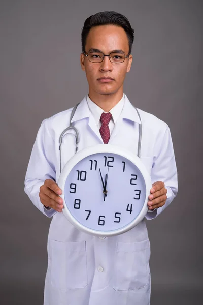 Joven guapo indio hombre médico contra gris fondo — Foto de Stock