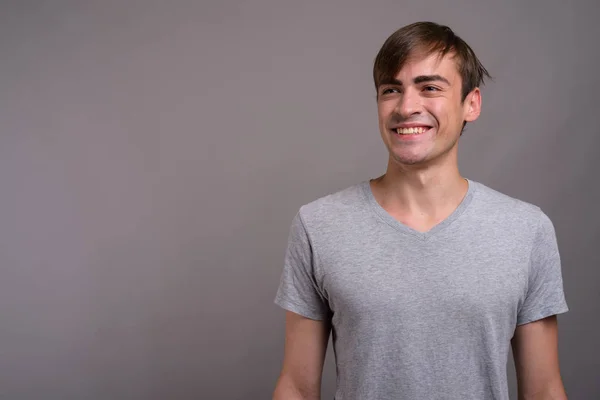 Junger gutaussehender Mann bereit für Fitnessstudio vor grauem Hintergrund — Stockfoto