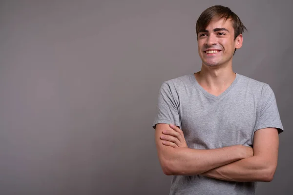 Young handsome man ready for gym against gray background — Stock Photo, Image