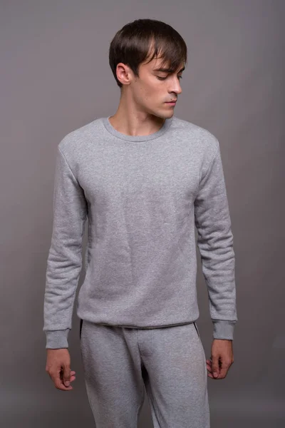 Young handsome man ready for gym against gray background — Stock Photo, Image