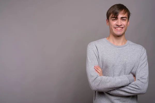 Jovem bonito homem pronto para ginásio contra fundo cinza — Fotografia de Stock