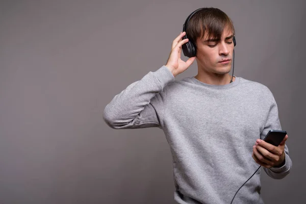 Junger gutaussehender Mann hört Musik und ist bereit für das Fitnessstudio gegen — Stockfoto