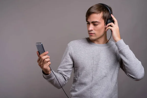 Junger gutaussehender Mann hört Musik und ist bereit für das Fitnessstudio gegen — Stockfoto