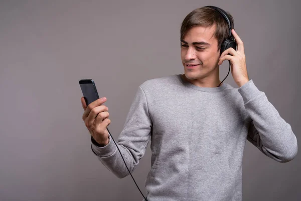 Junger gutaussehender Mann hört Musik und ist bereit für das Fitnessstudio gegen — Stockfoto