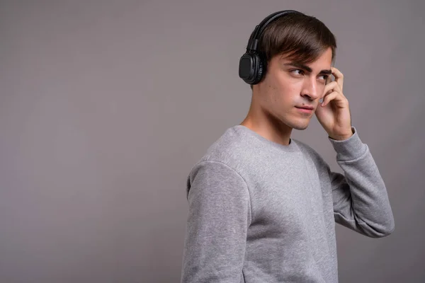 Junger gutaussehender Mann hört Musik und ist bereit für das Fitnessstudio gegen — Stockfoto