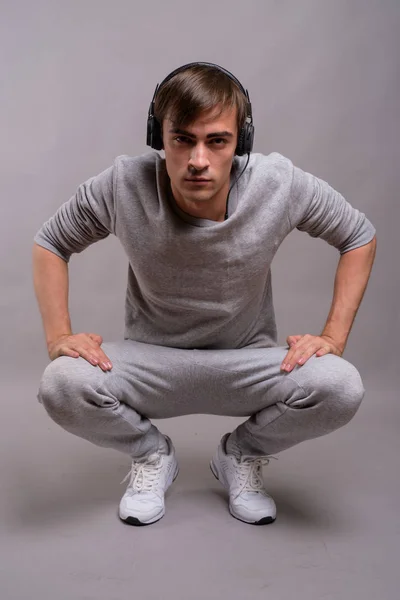 Junger gutaussehender Mann hört Musik und ist bereit für das Fitnessstudio gegen — Stockfoto