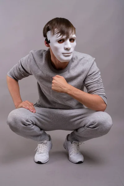 Studio Shot Van Jonge Man Wit Masker Dragen Terwijl Crouching — Stockfoto