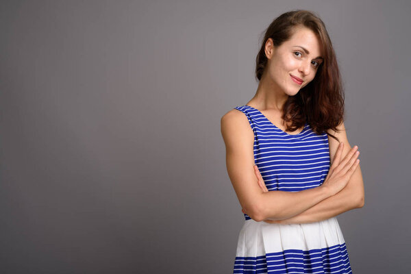 Young beautiful woman against gray background