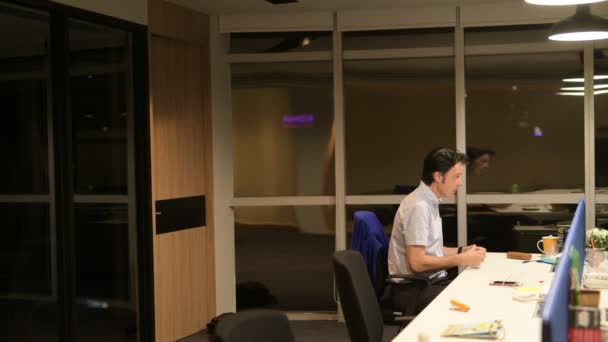 Homme d'affaires mature parlant dans le bureau la nuit 