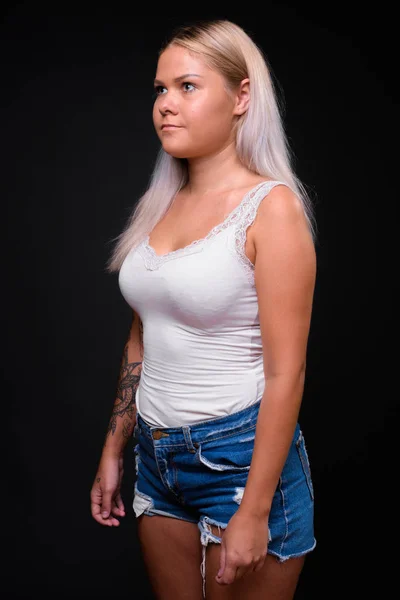 Junge schöne blonde Frau vor schwarzem Hintergrund — Stockfoto