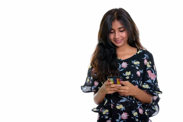 Studio shot of young happy Persian woman smiling while using mob — Stock Photo, Image