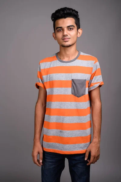 Junger indischer Mann mit grauem Hintergrund — Stockfoto