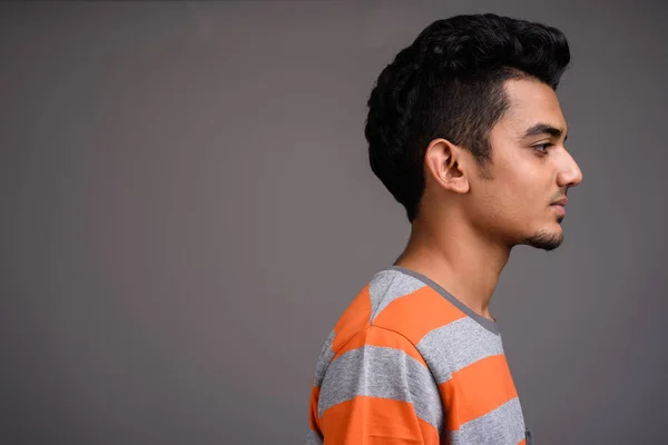 Unga indiska man mot grå bakgrund — Stockfoto