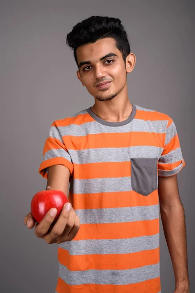Young Indian man against gray background — Stock Photo, Image