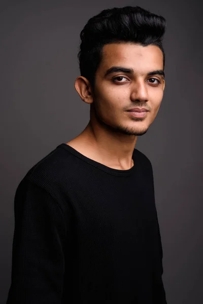 Junger indischer Mann mit grauem Hintergrund — Stockfoto