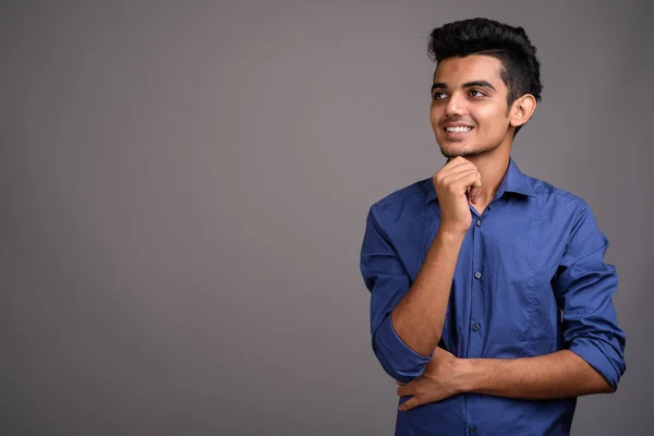 Молодой индийский бизнесмен на сером фоне — стоковое фото