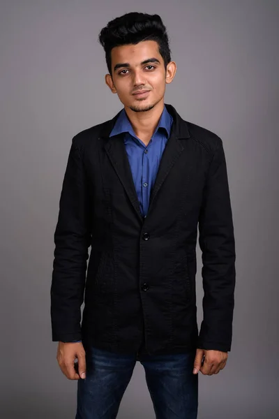 Mladý indický podnikatel šedém pozadí — Stock fotografie