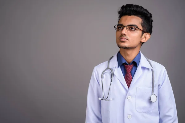Jeune homme indien médecin sur fond gris — Photo