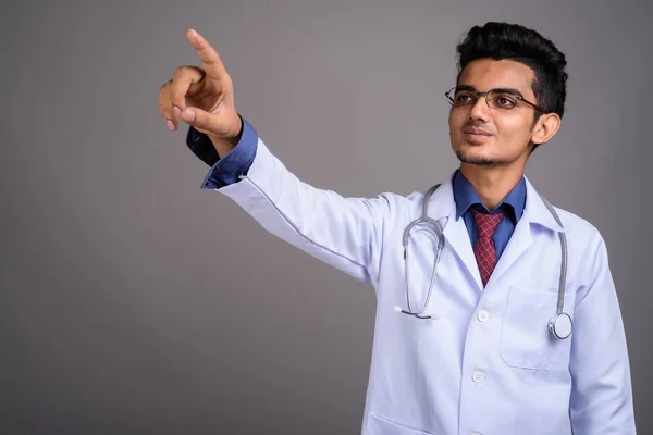 Mladý indický muž lékař šedém pozadí — Stock fotografie