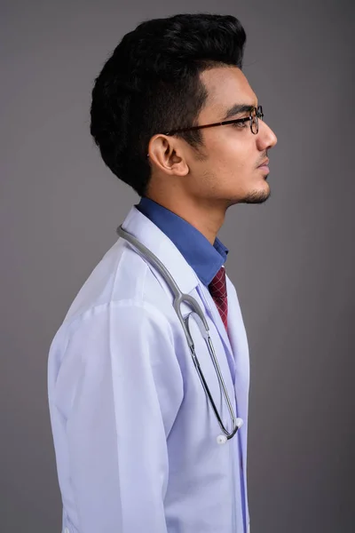 Jovem indiano homem médico contra fundo cinza — Fotografia de Stock