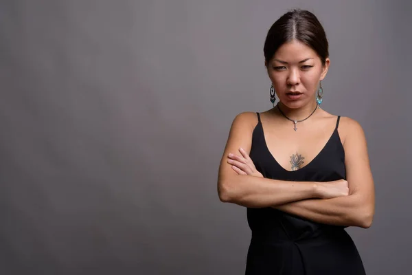 Young beautiful Kazakh woman against gray background — Stock Photo, Image