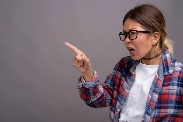 Junge schöne kasachische Frau vor grauem Hintergrund — Stockfoto