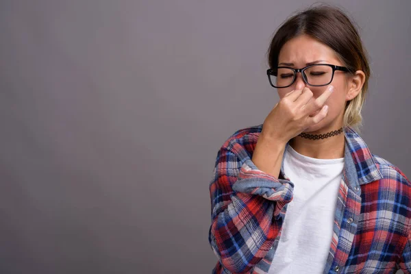 Junge schöne kasachische Frau vor grauem Hintergrund — Stockfoto