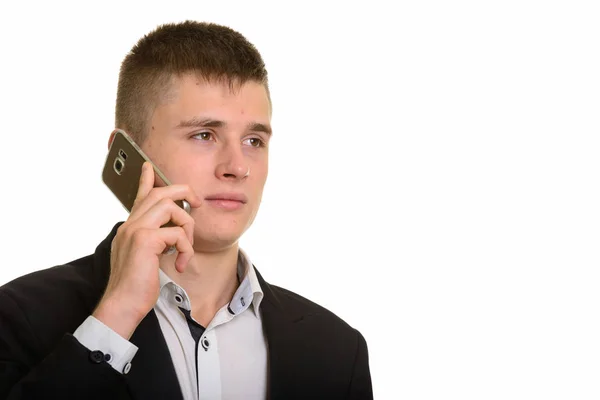 Estúdio tiro de jovem empresário falando no telefone celular enquanto t — Fotografia de Stock