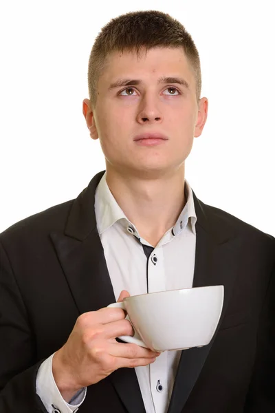 Närbild av ung affärsman som håller kaffekopp samtidigt tänker — Stockfoto