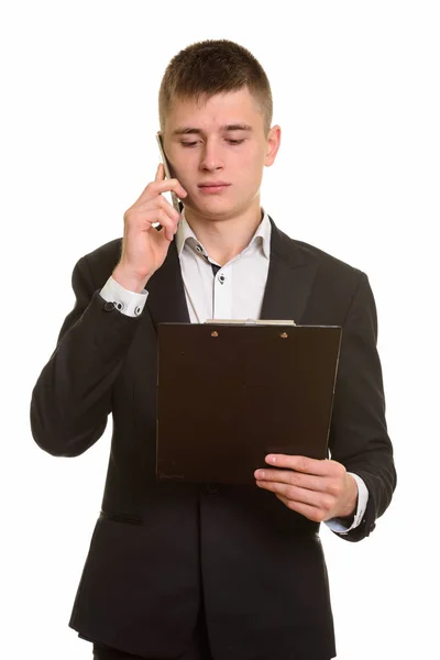 Studio shot van jonge zakenman praten op mobiele telefoon terwijl r — Stockfoto