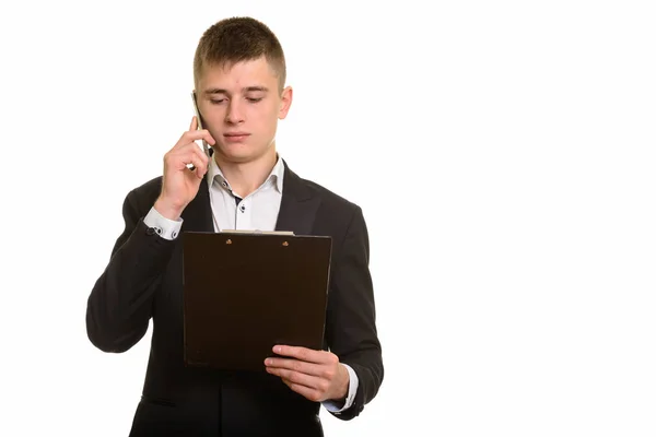 Studioaufnahme eines jungen Geschäftsmannes, der mit seinem Handy telefoniert, während er — Stockfoto