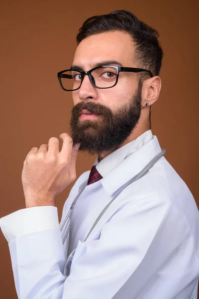 Studioaufnahme Eines Jungen Gutaussehenden Bärtigen Persischen Arztes Vor Braunem Hintergrund — Stockfoto