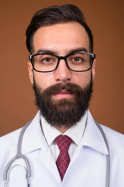 Studioaufnahme Eines Jungen Gutaussehenden Bärtigen Persischen Arztes Vor Braunem Hintergrund — Stockfoto