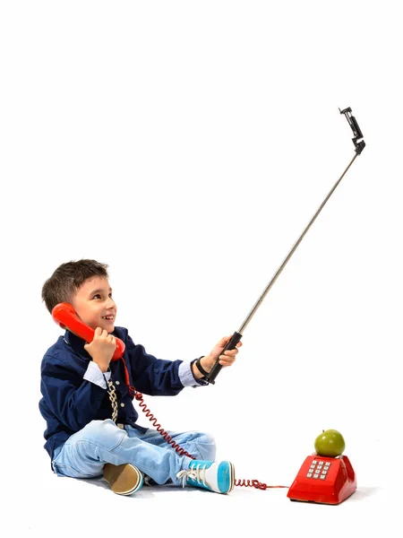 Studio shot of cute happy boy smiling and talking on old telepho — Stock Photo, Image