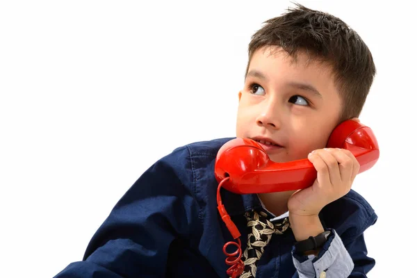 Studio menembak anak laki-laki lucu berbicara di telepon tua sambil berpikir — Stok Foto