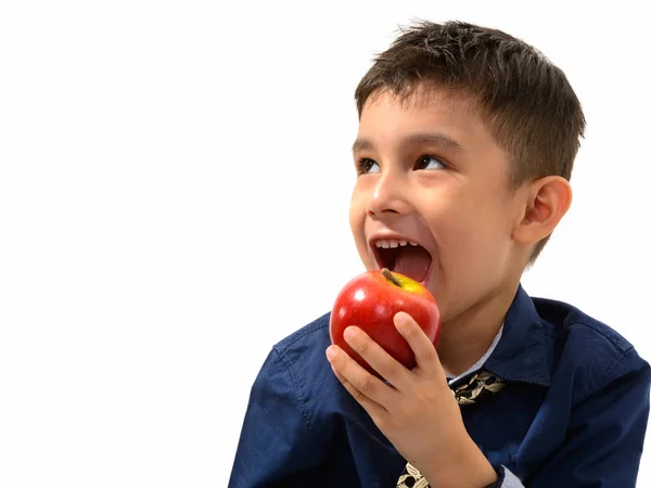 Estudio disparo de lindo niño feliz sonriendo y comiendo manzana mientras thi —  Fotos de Stock