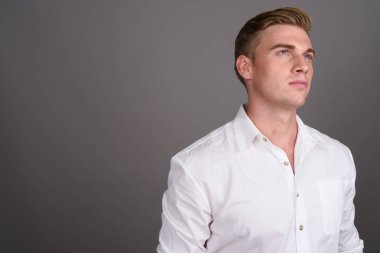 Gri backgrou karşı sarışın saçlı Genç yakışıklı işadamı