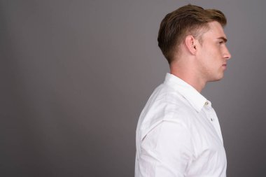 Gri backgrou karşı sarışın saçlı Genç yakışıklı işadamı