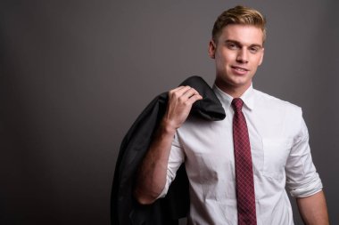 Gri backgrou karşı sarışın saçlı Genç yakışıklı işadamı