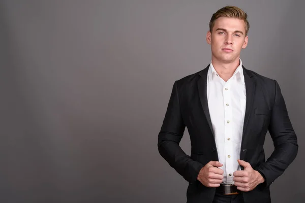 Karşı takım elbise giymiş sarışın saçlı Genç yakışıklı işadamı 