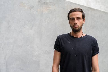 Yakışıklı adam açık havada sokaklarda beton duvara